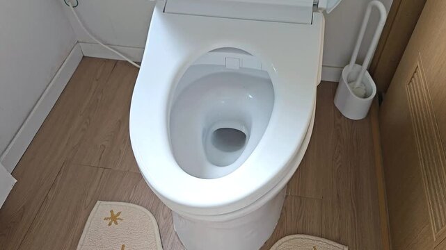 Smart toilet automatically opening lid with motion sensor. Close up footage of touchless sensor activated toilet in modern home bathroom interior