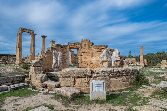 Exploring the ancient ruins of Cyrene in Eastern Libya with stone structures and sculptures visible under a blue sky