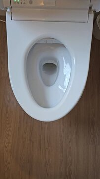 Japanese smart toilet automatically opening lid after hand motion detected by proximity sensor. Modern touchless toilet footage demonstrating automatic lid opening with motion sensor technology