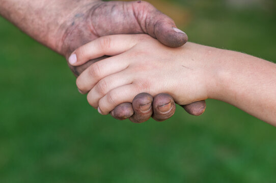 Adult Hand Supporting Child's Hand Symbolizing Care and Guidance
