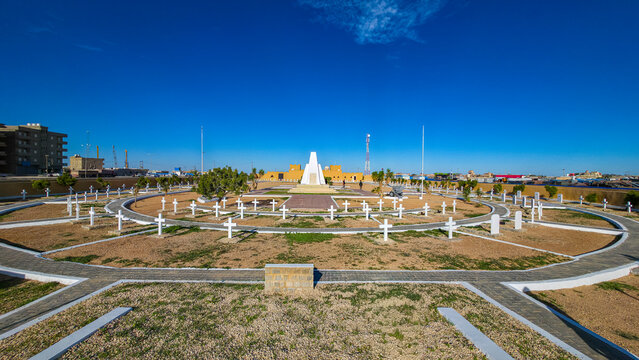 French World War 2 cemetery honors soldiers in Tobruk, featuring gravestones and a monument surrounded by clear blue sky in Libya