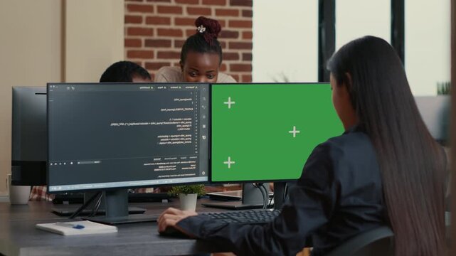 Cybersecurity programmer works at a desk with chroma key screen replacement, combining algorithm development, software testing and mockup presentation