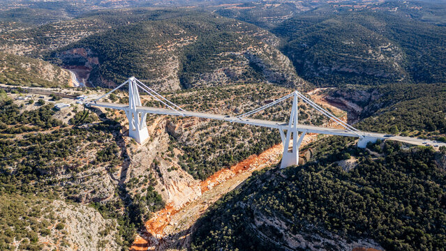 View of a large bridge spanning the Gorge Wadi al Kuf in Eastern Libya amidst mountainous terrain and greenery