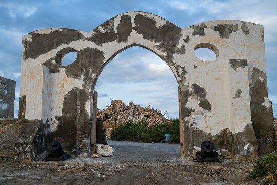 Historic gate structure in Suakin Island with remnants of old buildings in background during late afternoon in Sudan