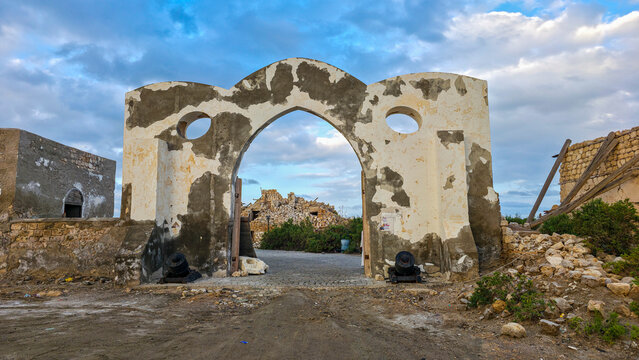 Historic entrance to ruins on Suakin Island, showing coral structures and weathered walls at sunset in Sudan