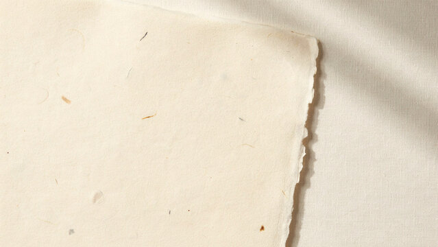 Cream colored handmade paper with deckled edge a close up overhead studio shot texture off-white