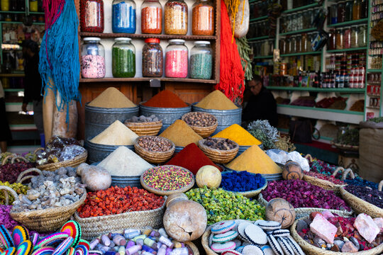 Visitors explore a market filled with colorful spices and handmade souvenirs in Marrakesh, Morocco