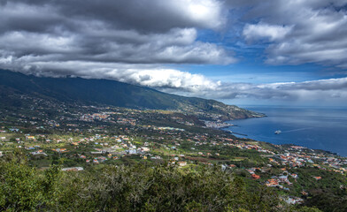 Naklejka premium Vista panorámica de la costa este de La Palma bajo un cielo de nubes dramáticas