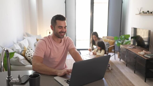 Father working from home on laptop computer