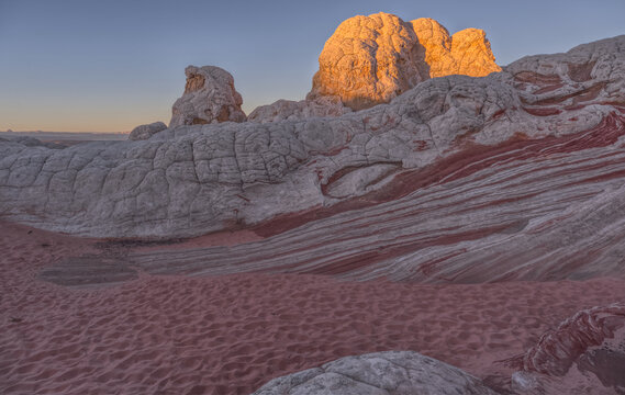 Colorful sandstone formations at White Pocket reveal unique textures and patterns at sunrise in Arizona