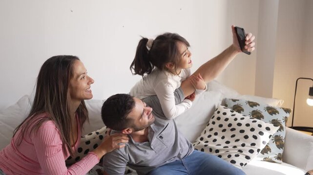 Happy family taking funny selfies together on the sofa