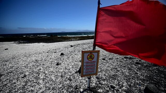 Red Warning Flag Blowing at Popcorn Beach, Dangerous Swimming Conditions and Strong Currents, Corralejo, Fuerteventura, Canary Islands