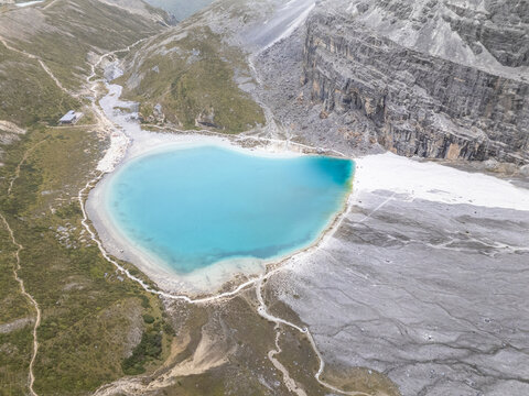Heart-shaped Milk Lake in Yading National Park offers aerial view of turquoise water and surrounding mountains