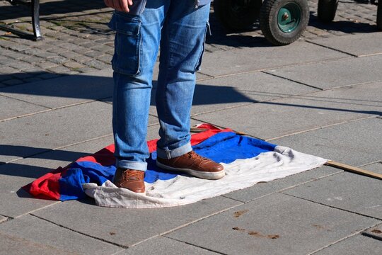Ukrainian protester trampling on Russian Federation flag during rally against war in Oslo, Norway