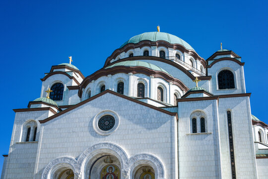 Saint Sava Church shows its domes and crosses under a clear blue sky in Belgrade Serbia