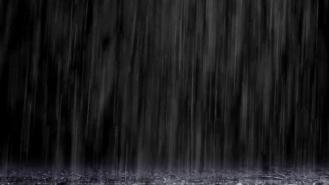 Rain falls heavily against a dark background creating a vertical pattern of motion and liquid flow.