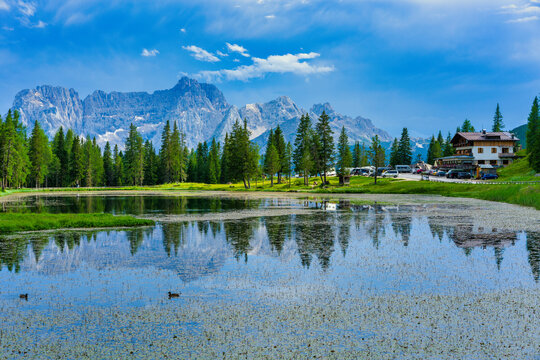 Reflection of Dolomites mountains and alpine refuge at Lake Antorno in Misurina, Veneto, Italy