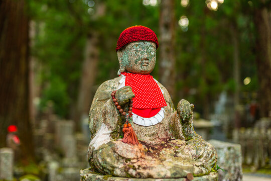 Stone Jiz statue wearing red knit hat and bib at Okunoin Cemetery in Mount Koya, Wakayama