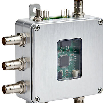 Brushed metal electronic device featuring multiple bnc connectors and an exposed green integrated circuit board
