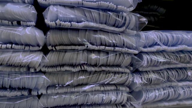 Close-Up of Packaged Disposable Plastic Cutlery (Plastic Utensils) Stacked in Transparent Polyethylene Bags, 4K 60fps