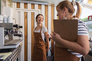 Coffee shop owner supervising young trainee barista learning work © PintoArt