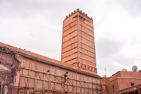 Minaret of Koutoubia Mosque stands tall in Marrakesh surrounded by historical buildings and local architecture