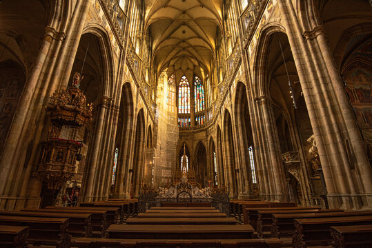 Interior view of St. Vitus Cathedral showing Gothic columns and ornate altar in Prague Castle
