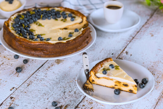 Bakery display cheesecake with blueberries cup of coffee on wooden table