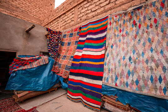 Woven carpets display in a narrow alley of a Moroccan medina showcasing local textile skills and craftsmanship