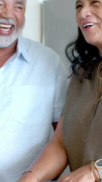 Vertical video: Smiling after talk, lady in olive top leaning and handling oil at home with citrus