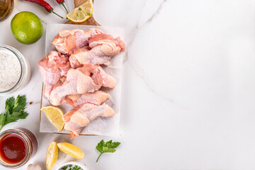 Fresh raw organic chicken wings, with spices and condiments © ricka_kinamoto