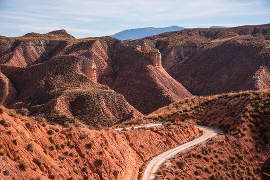 Winding dirt road traverses the badlands in the Gorafe Desert in northeastern Granada province, Spain