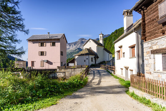 Residential lane showcasing alpine buildings and larch trees in Alpe Devero village, Italy