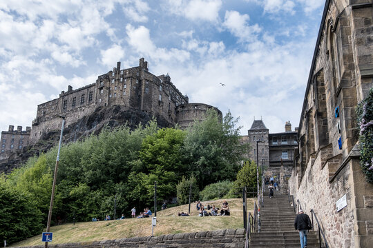 Majestic view of fort that sits on a rock and overlooks a city with people enjoying the day in Scotland