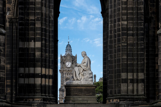 Scott Monument architecture shows statue with clock tower in background in Edinburgh Scotland
