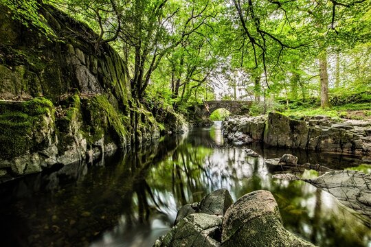 A sunny day mixed with showers seen from Trough House Bridge over the river Esk in Cumbria