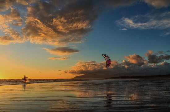 Kitesurfer enjoys the waves against the backdrop of Black Combe and the setting sun on the Cumbrian Coast