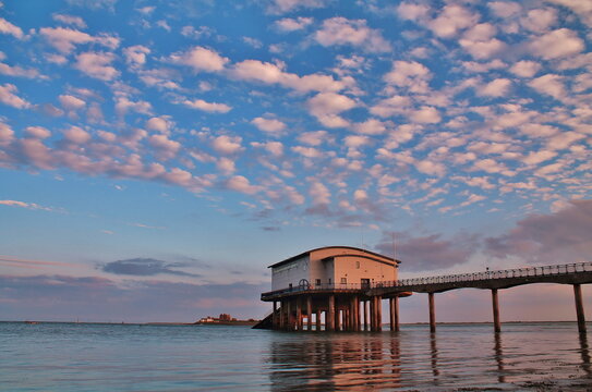 View from Roa Island Lifeboat Station showing Piel Island in the distance under a colorful sky in Cumbria