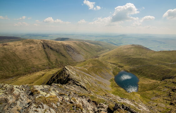 Exploring sharp edge blencathra with scales tarn in the background of the english lake district