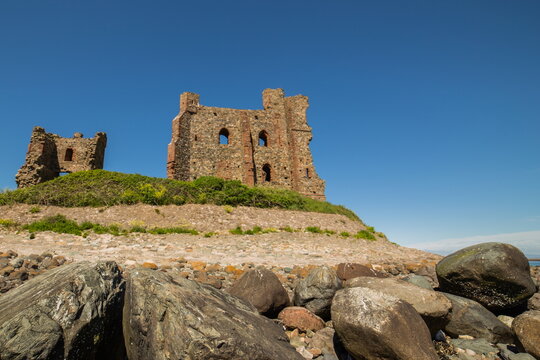 View of Piel Castle on the Cumbrian Coast surrounded by rocks and grass under a clear blue sky