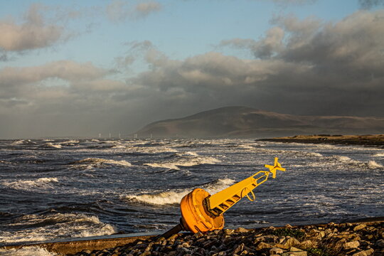 Washed-up buoy on the Cumbrian coast with Black Combe in the background on a stormy day
