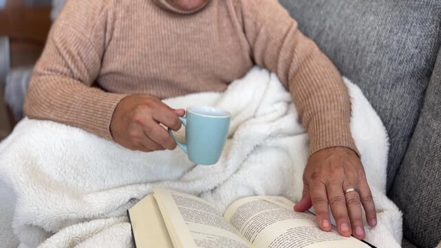 &Oacute;rbita de hombre abrigado leyendo en el sof&aacute;