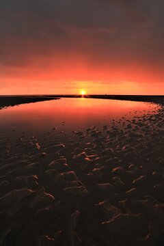 Sunset view over Walney Island reflecting on the water during low tide on the Cumbrian Coast