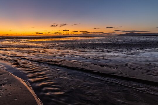 Dramatic sunset viewed from Walney Island towards Black Combe in Barrow In Furness at low tide