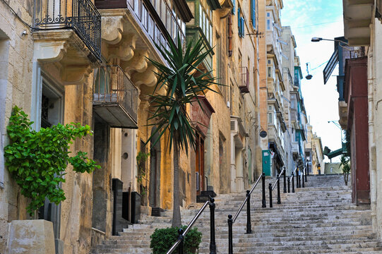 Stairs lead up through historic buildings in Valletta, showcasing the architecture and life of Malta