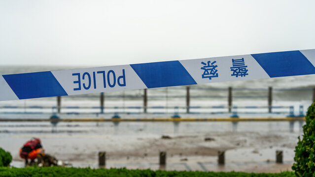 Police Barrier Tape Marking Restricted Outdoor Area Near Waterfront