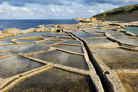 Salt pans along the north coast of Gozo Island capture the Mediterranean sunlight during late afternoon hours