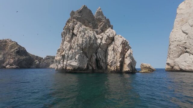 Dramatic sea stack surrounded by flying birds