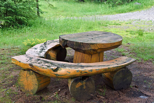 Picnic table made of wood in Chocholowska Valley surrounded by grass and trees in Polish Tatra mountains