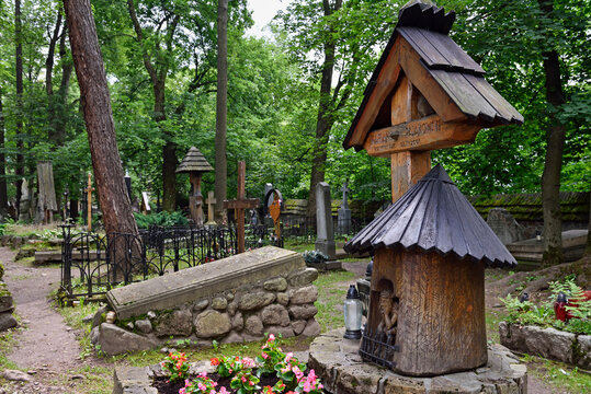 Worried Christ representation on wooden funerary stela in old cemetery surrounded by trees in Poland
